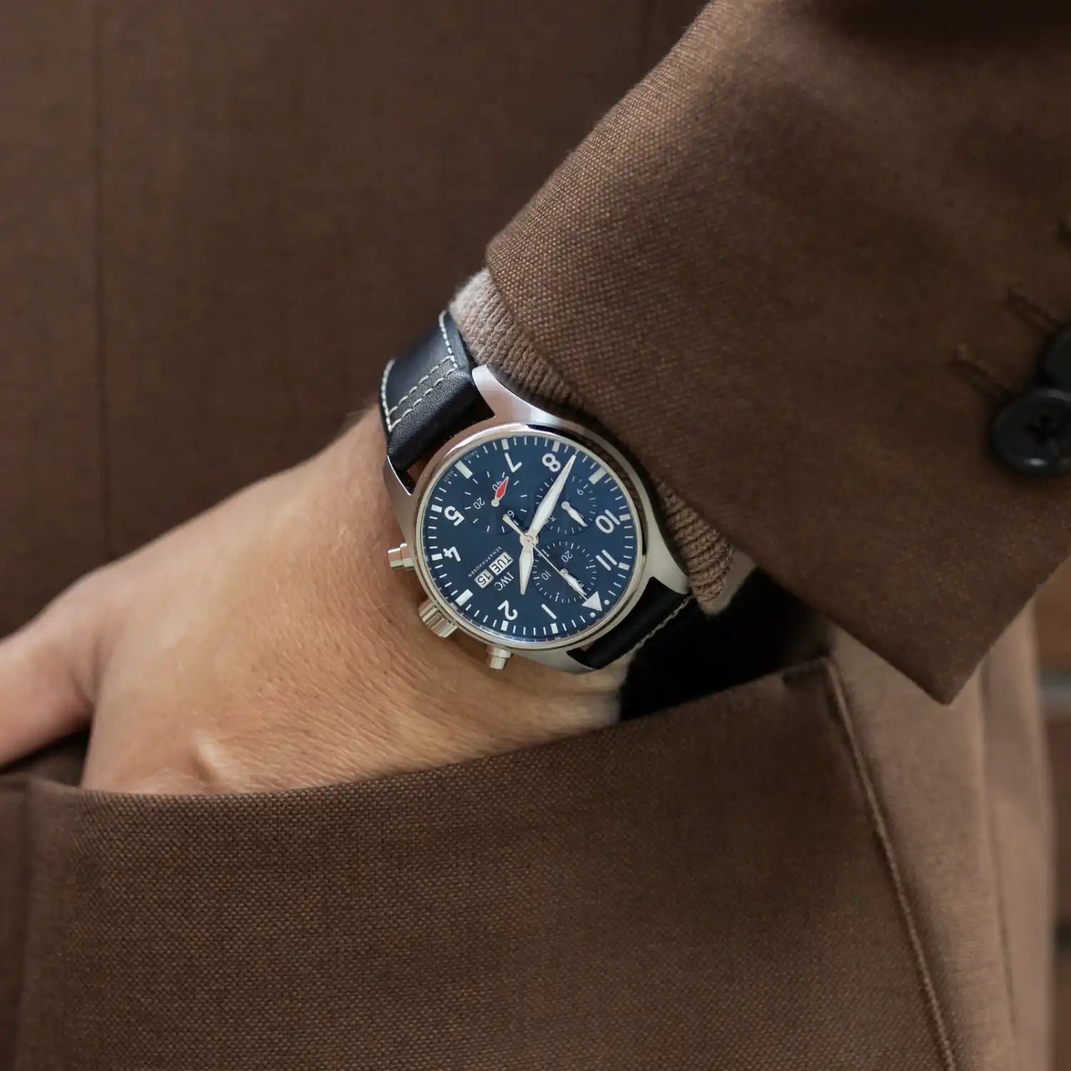 IWC men’s wristwatch with blue dial and leather strap worn on the wrist