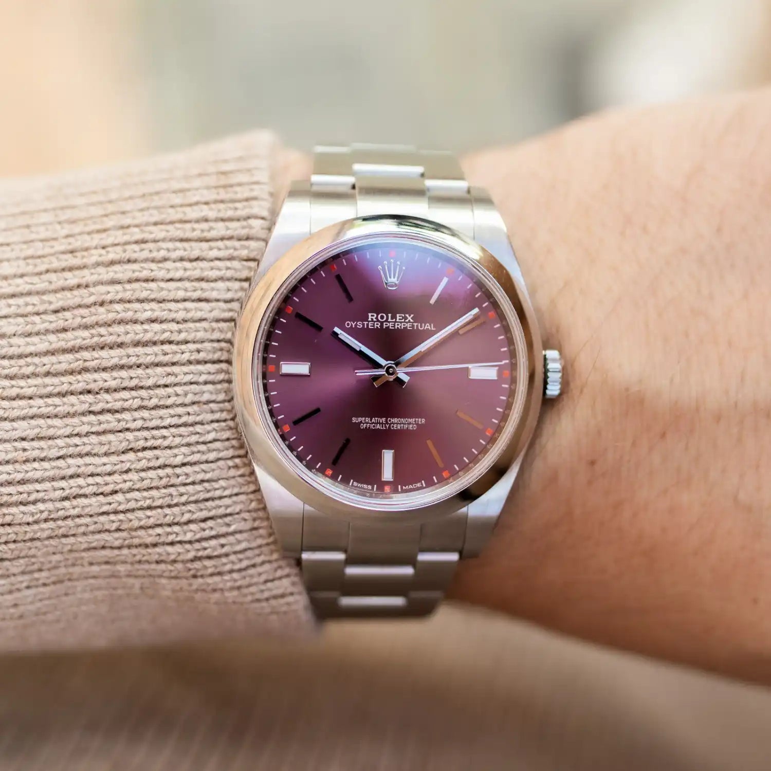 Rolex Oyster Perpetual wristwatch with burgundy dial worn on the wrist